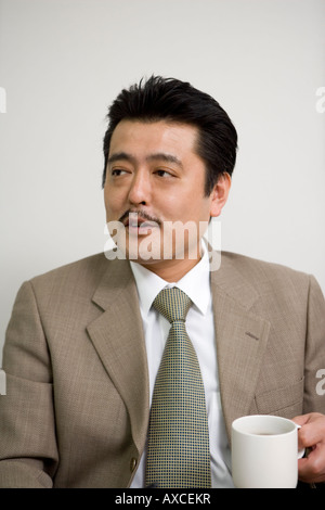 Businessman holding cup of coffee Stock Photo