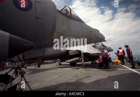 RAF armourers bomb up a Harrier GR7 s of 1 Sqn RAF on the Royal Navy aircraft carrier HMS Illustrious Stock Photo