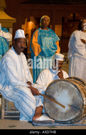 Vertical close up of traditional Moroccan singers and musicians playing the 'bendir' drum at night. Stock Photo