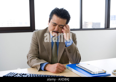 Businessman with hand on forehead Stock Photo