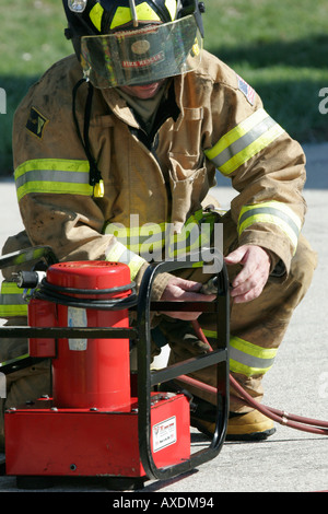 A fire fighter is starting up a red generator for the extrication ...