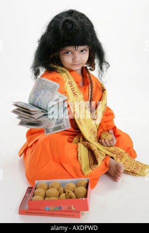 Portrait of a boy in priest clothing offering money Stock Photo