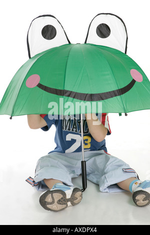 Boy hiding his face under an umbrella Stock Photo
