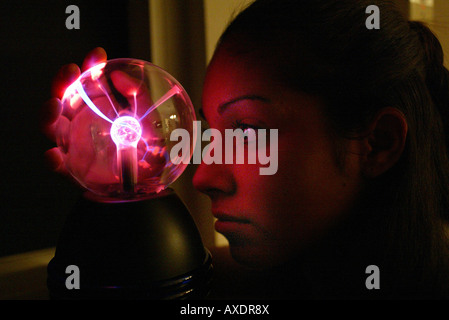 Teen girl stares at plasma lamp Stock Photo