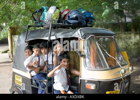 Young Indian schoolboys on the way to school in a rickshaw a popular mode of school transport Fort Kochi Cochin Kerala India Stock Photo