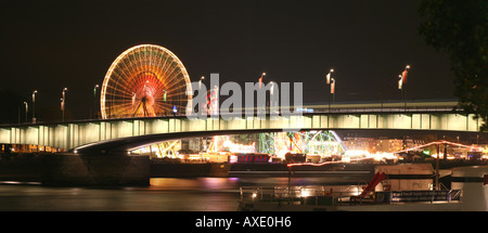 Panorama across Deutzer bridge over the Rhine river and fair lights with the big wheel in Cologne, NRW, Germany Stock Photo