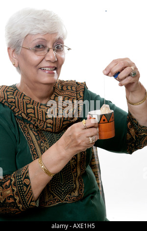 Portrait of a senior woman preparing tea with tea bag Stock Photo