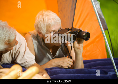 Senior couple camping, woman with field glasses, portrait Stock Photo