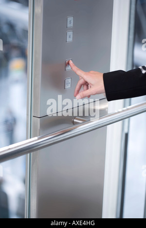 Female hand pressing lift button, close-up Stock Photo