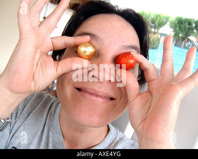 Woman hiding her eyes behind candies Stock Photo