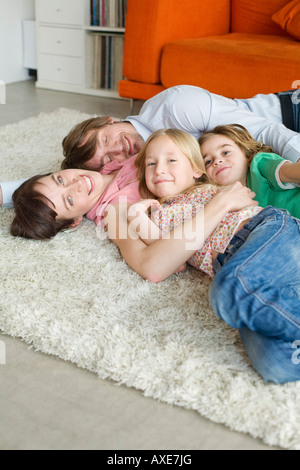 Family lying on floor in living room Stock Photo
