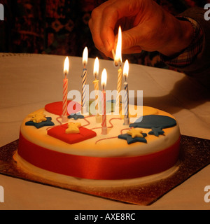 Lighting candles on a birthday cake Stock Photo