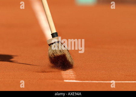 Brushing lines on tennis court Stock Photo