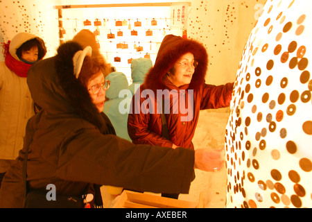 Putting the coins on the ice for good luck at Sounkyo Ice Festival Stock Photo