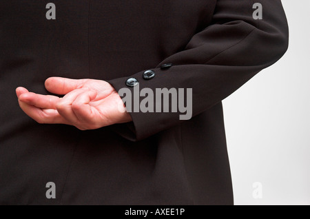 Businesswomans hand with fingers crossed behind back close up