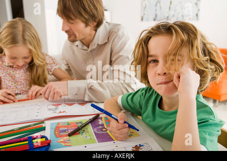 Father and children doing homework Stock Photo