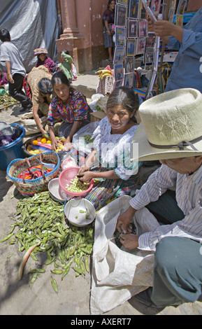 GUATEMALA CHICHICASTENANGO Local Quiche family shelling and selling beans and other vegetables on the street Stock Photo