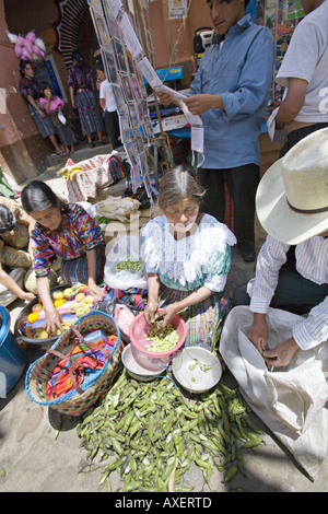 GUATEMALA CHICHICASTENANGO Local Quiche family shelling beans and selling vegetables on the street Stock Photo