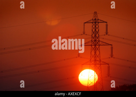 An electricity pylon  with the sun setting behind Stock Photo