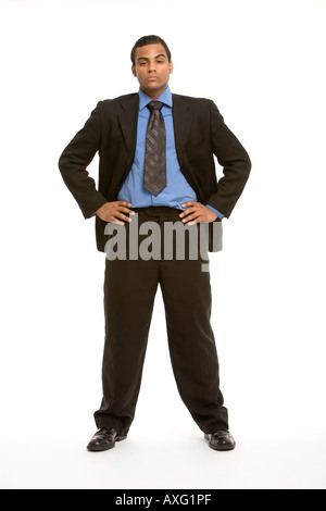 Young business man in a suit and tie standing with feet apart and arms akimbo Stock Photo