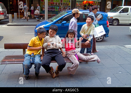 Chinese children on street bench in Sydney Stock Photo