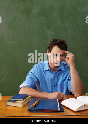 Teacher Reading at Desk Stock Photo