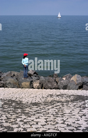 woman looking at the sea from a dyke Stock Photo