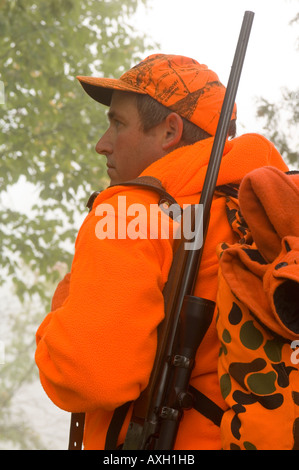 PORTRAIT OF A DEER HUNTER IN BLAZE ORANGE WITH RUGER MODEL ONE RIFLE WITH BAUSCH AND LOMB SCOPE ON HIS BACK NORTHERN MINNESOTA Stock Photo