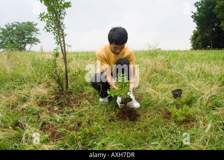 Young man planting tree Stock Photo