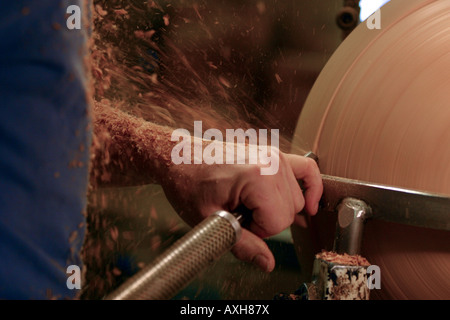 A craftsman works on a lathe inside his workshop. Stock Photo