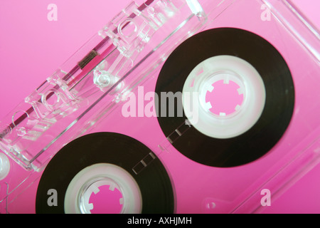 Close up of a Transparent Audio Cassette tape on a pink background. Stock Photo