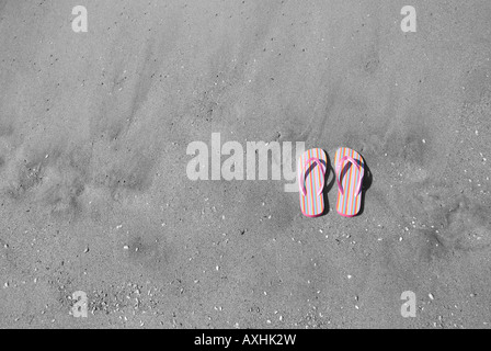 A pair of pink flip flops in the sand Stock Photo