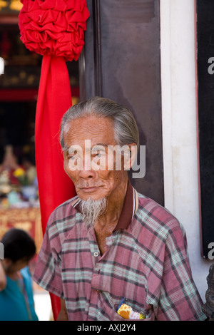 Begging man with a coin in his ear at the Cheng Hoon Teng Temple, Melaka, Malaysia. Stock Photo