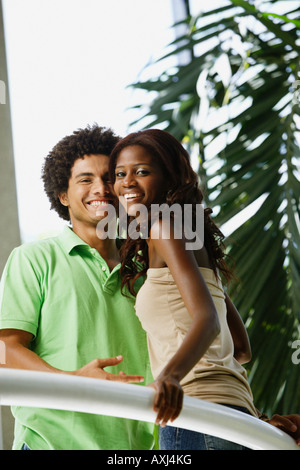 South American couple leaning on railing Stock Photo