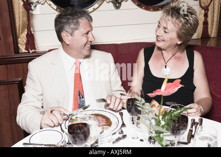 Mature woman taking food with a senior man and smiling Stock Photo