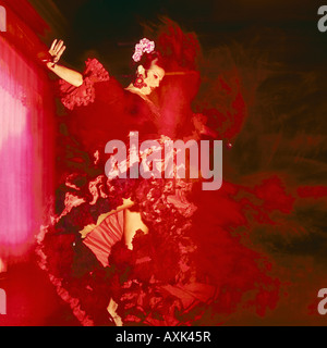 Female Spanish flamenco dancer wearing deep red coloured flaring dress in fast action performance dancing Spain Stock Photo