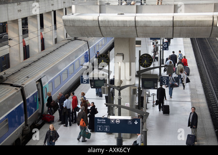 SNCF train with passengers on platform in TGV railway station Charles De Gaulle International Airport or Aeroport Paris France Stock Photo