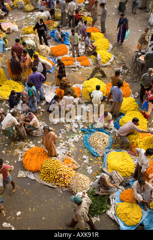 Buyers and sellers mill around in the colourful Mullick Ghat Flower Market near to the Howrah Bridge in Kolkata. Stock Photo