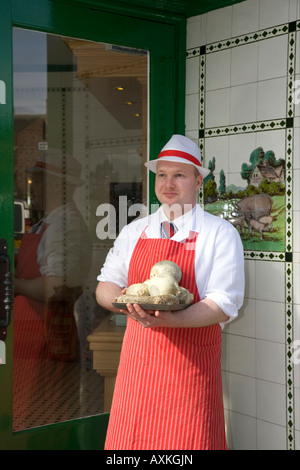 Butcher standing in Shop Doorway wearing Red Apron  W Irvine Butchers Blairgowrie, Scotland UK Stock Photo