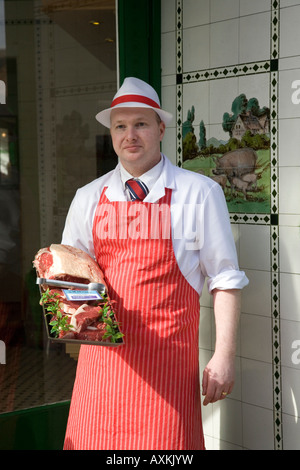 Butcher standing in Shop Doorway wearing Red Apron  W Irvine Butchers Blairgowrie, Scotland UK Stock Photo