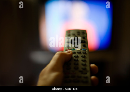 Man holds buttons while watching TV Stock Photo