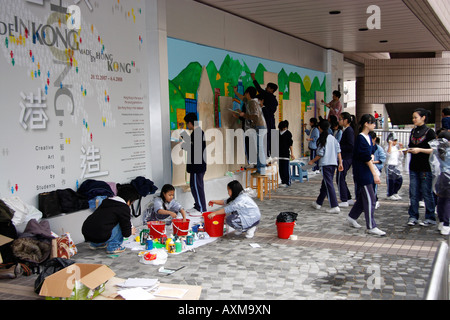 Hong Kong school art class painting murals on a wall of ...