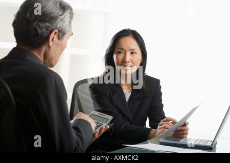 Asian businesswoman talking to businessman Stock Photo