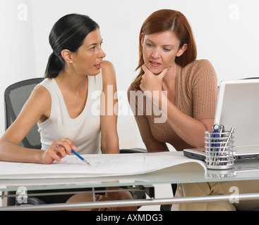 Two businesswomen looking at blueprints Stock Photo