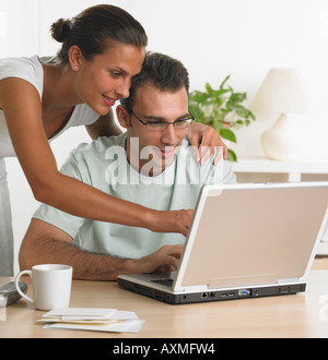 Couple using laptop at table Stock Photo