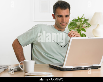 Man using laptop at table Stock Photo