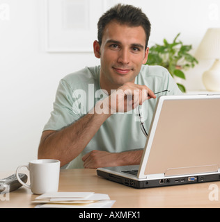 Man using laptop at table Stock Photo