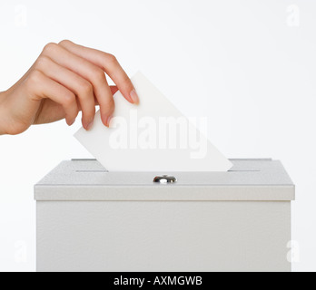 Close up of woman s hand putting card in box with slot Stock Photo