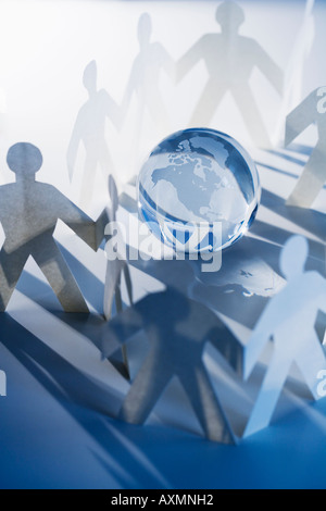 Chain of paperdoll cutouts with globe in center Stock Photo