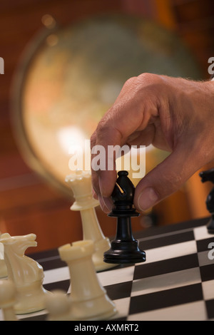 Hand moving chess piece Stock Photo